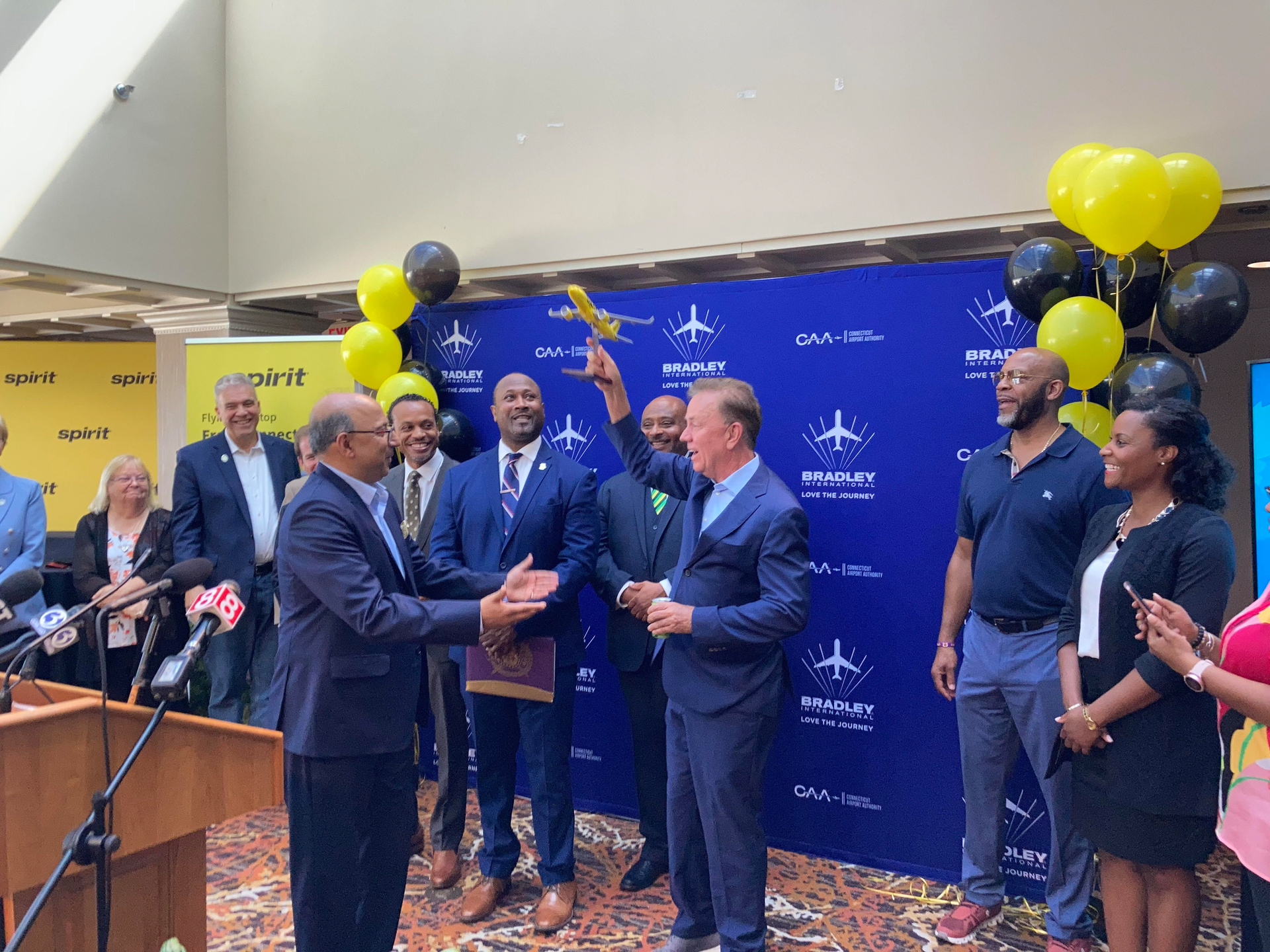Gov. Ned Lamont, at right, holds up a model of a Spirit Airline passenger aircraft presented to him in September by Spirit's Senior Director, Airports Atul Kumria. The gift marked the announcement at Bradley International Airport that Spirit will offer a nonstop flight to Jamaica.