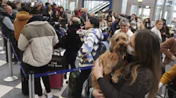 Emily Colfer and her dog, Archie, stand in the dog line in Terminal 1 at Chicago O Hare International Airport on Dec. 21, 2022. Colfer and her pup were on their way to Maine for the holiday season.