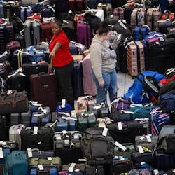An employee at the Sacramento International Airport Terminal B near the Southwest carousel points to luggage on Tuesday, Dec. 27, 2022, that is being held after canceled and delayed flights over the Christmas rush.
