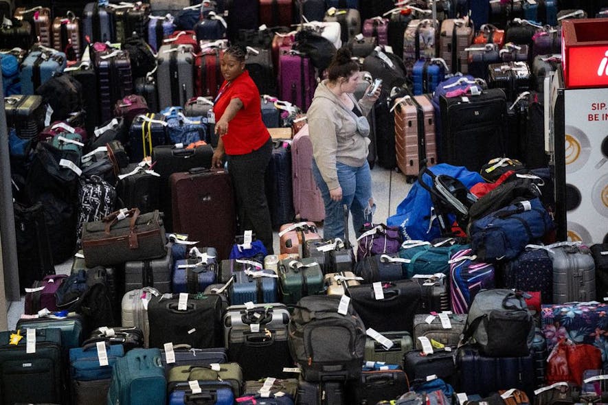 An employee at the Sacramento International Airport Terminal B near the Southwest carousel points to luggage on Tuesday, Dec. 27, 2022, that is being held after canceled and delayed flights over the Christmas rush.