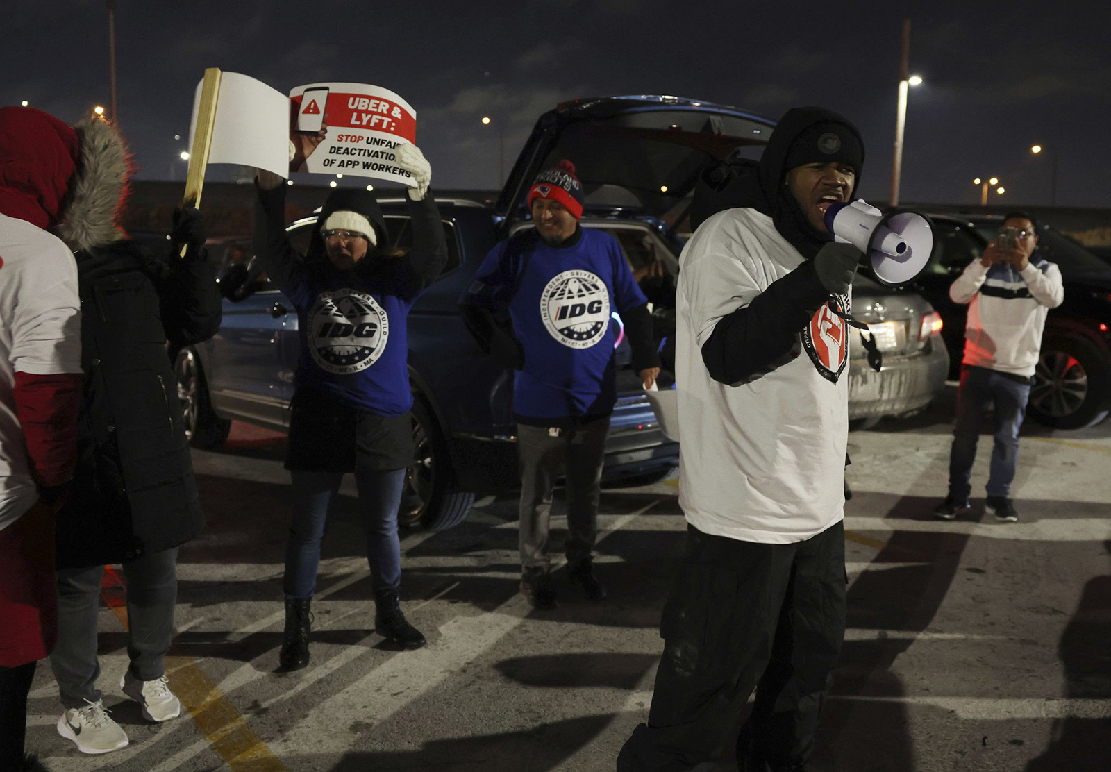 Steven Everett yells into a megaphone during a protest by ride-share drivers at a lot near O'Hare International Airport on Dec. 27, 2022. Drivers held a rally to bring attention to wage issues and deactivations without review.