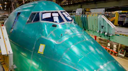 The giant nose section of the final 747 sticks up from beneath a deck before it is craned into position during the final body join.