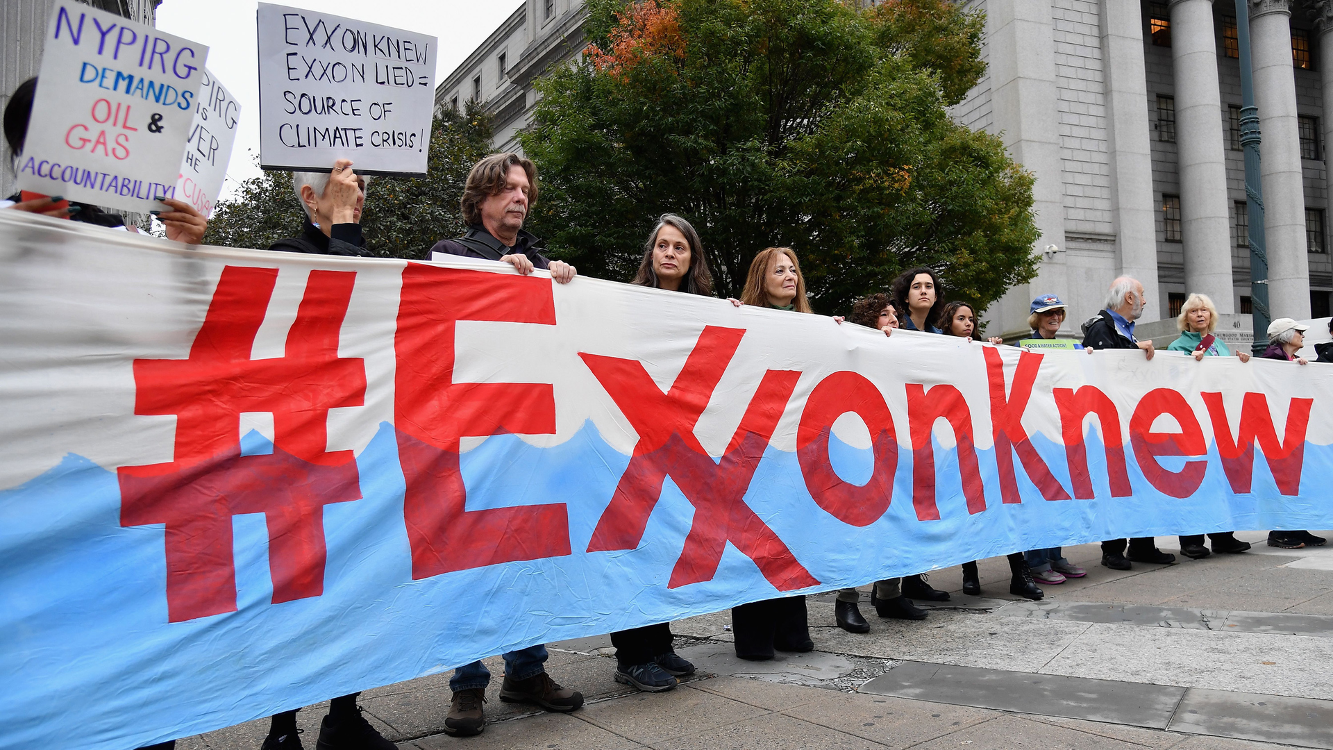Climate activists protest on the first day of the Exxon Mobil trial outside the New York State Supreme Court building on Oct. 22, 2019, in New York City. New York&rsquo;s attorney general was taking on Exxon Mobil in a landmark case that accused the oil giant of misleading investors about the company&rsquo;s financial risks due to climate change.