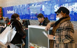 Denise Simon Mattei, left, checks bags for herself and Elaine Simon's , right, journey back to Baltimore with a Southwest Airlines agent at Dallas Love Field Airport on Dec. 27, 2022.