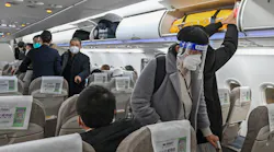 A passenger wearing a face shield and mask amid the COVID-19 pandemic boards a domestic flight at Shanghai Pudong International Airport in Shanghai on Jan. 3, 2023.