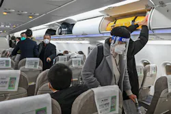 A passenger wearing a face shield and mask amid the COVID-19 pandemic boards a domestic flight at Shanghai Pudong International Airport in Shanghai on Jan. 3, 2023.