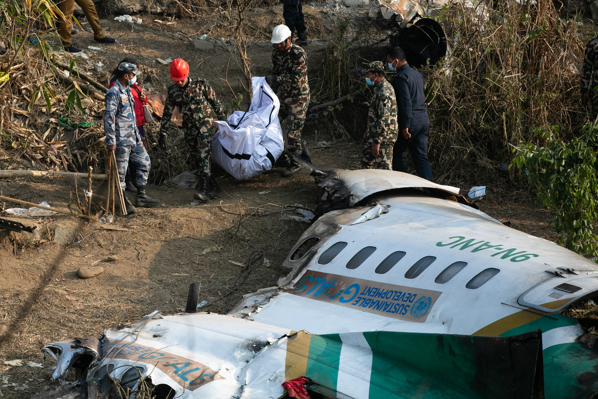 Nepal army, police and rescuers recover the body of a victim who died in a Yeti Airlines plane crash in Pokhara, Monday, Jan. 16, 2023.