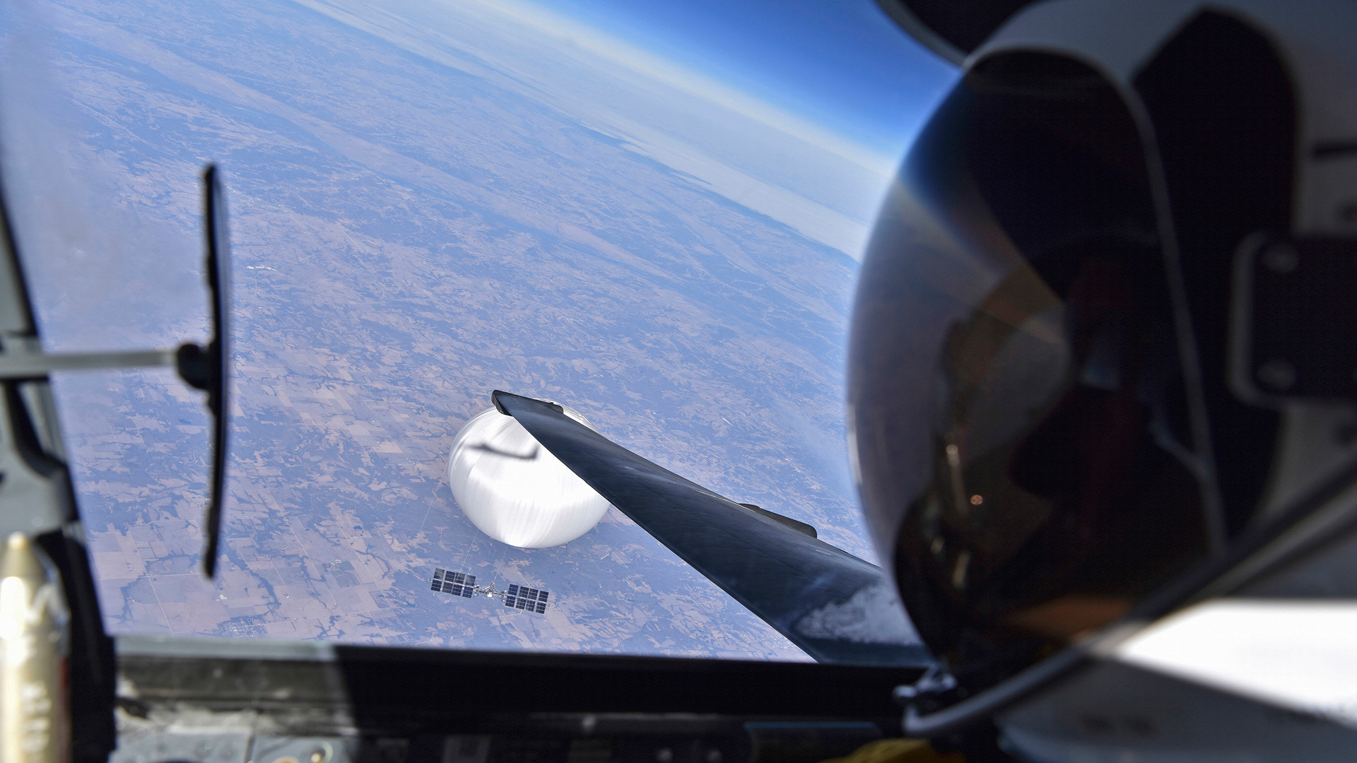 In a handout image provided by the Department of Defense, a U.S. Air Force U-2 pilot looks down at the suspected Chinese surveillance balloon on Feb. 3, 2023, as it hovers over the Central Continental United States. Recovery efforts began shortly after the balloon was downed.