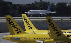 A JetBlue airliner takes off past Spirit Airlines planes at Fort Lauderdale-Hollywood International Airport. JetBlue is waging major campaign to win federal approval for its proposed Spirit buyout, which is opposed by some who claim it will diminish competition.