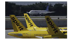 A JetBlue airliner takes off past Spirit Airlines planes at Fort Lauderdale-Hollywood International Airport. JetBlue is waging major campaign to win federal approval for its proposed Spirit buyout, which is opposed by some who claim it will diminish competition.