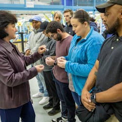 Kim Howard, vice president, Integrated Fighter Group Production Operations at Lockheed Martin, presents new apprentices with F-16 lapel pins and challenge coins.