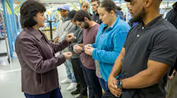 Kim Howard, vice president, Integrated Fighter Group Production Operations at Lockheed Martin, presents new apprentices with F-16 lapel pins and challenge coins.