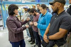 Kim Howard, vice president, Integrated Fighter Group Production Operations at Lockheed Martin, presents new apprentices with F-16 lapel pins and challenge coins. Kim Howard, vice president, Integrated Fighter Group Production Operations at Lockheed Martin, presents new apprentices with F-16 lapel pins and challenge coins.