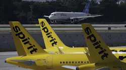 A JetBlue airliner takes off past Spirit Airlines planes parked at Fort Lauderdale-Hollywood International Airport. The federal government is suing to block Spirit's takeover by JetBlue, which hopes a settlement with the state of Florida will help pave the way for a resolution.