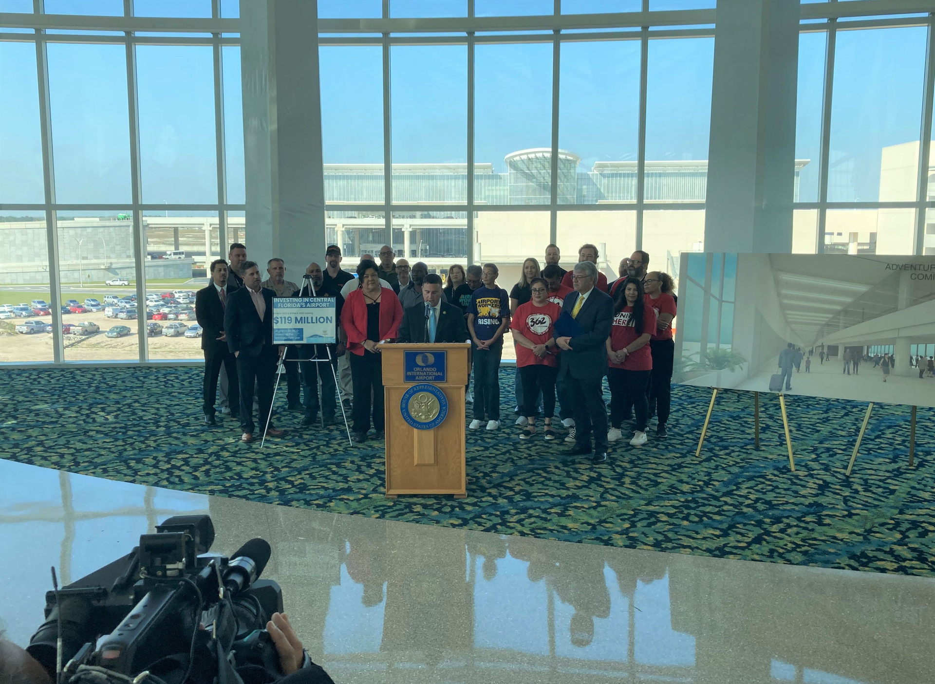 U.S. Rep. Darren Soto announced Monday $69 million in infrastructure funding for Orlando's airport. Some of the money would pay for connecting the train station, where Soto and various airport workers appeared for the announcement, with Terminal C in the background via an elevated pedestrian bridge.