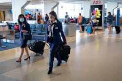 American Airlines flight attendants walk along the concourse at DFW International Airport. American Airlines flight attendants walk along the concourse at DFW International Airport.