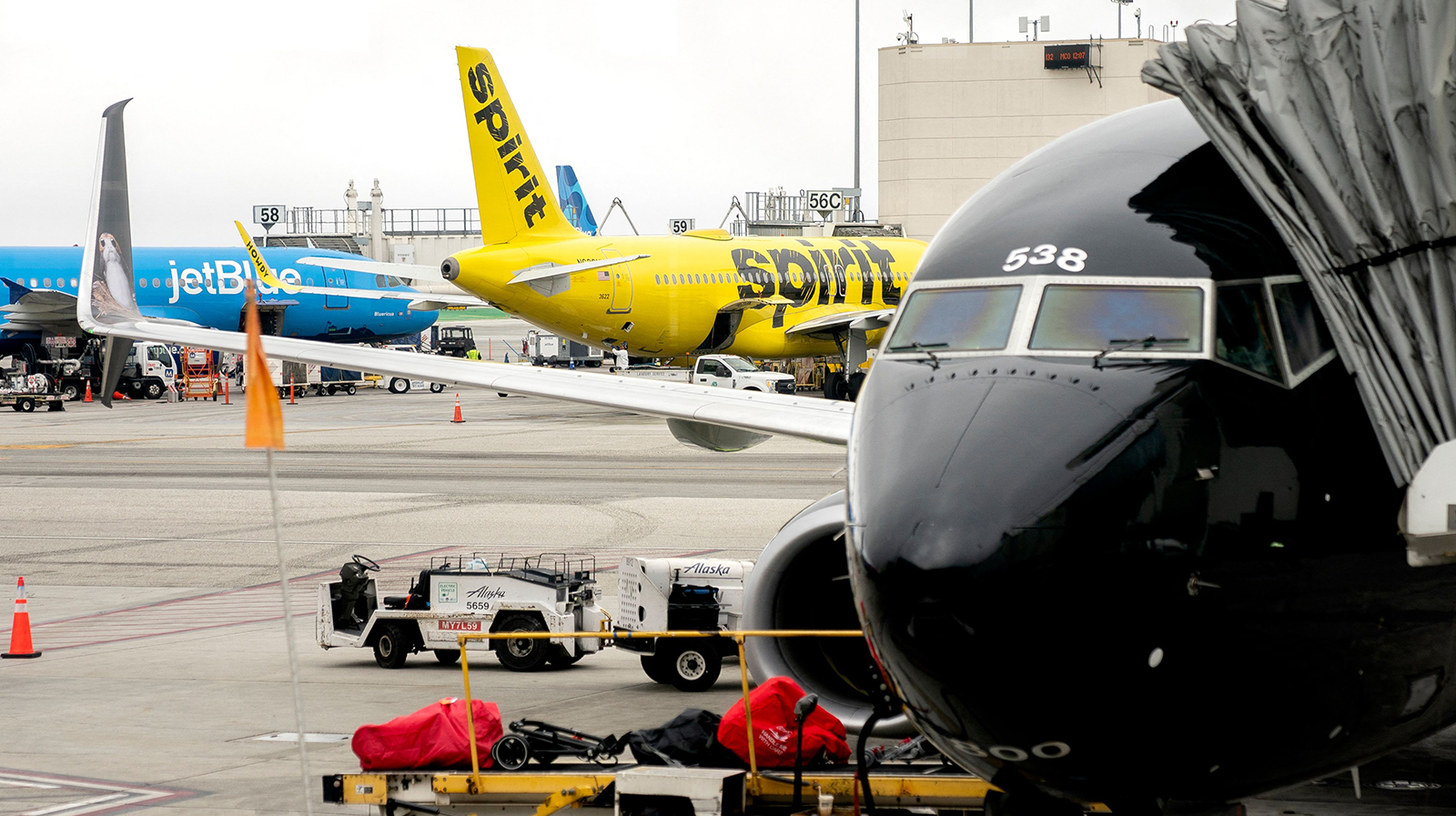 A JetBlue airplane and Spirit Airlines airplane sit at Los Angeles International Airport in Los Angeles, California, on March 13, 2023.