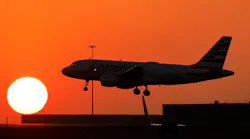 An American Airlines jet lands before the setting sun at Dallas/Fort Worth International Airport, Feb. 15, 2023.