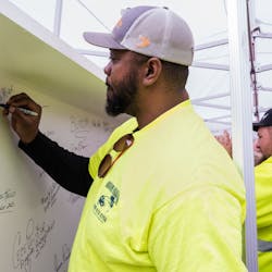 Eugene Walker, Heavy Equipment Operator for the Allegheny County Airport Authority, signs the final steel beam for the airport&rsquo;s new terminal structure.