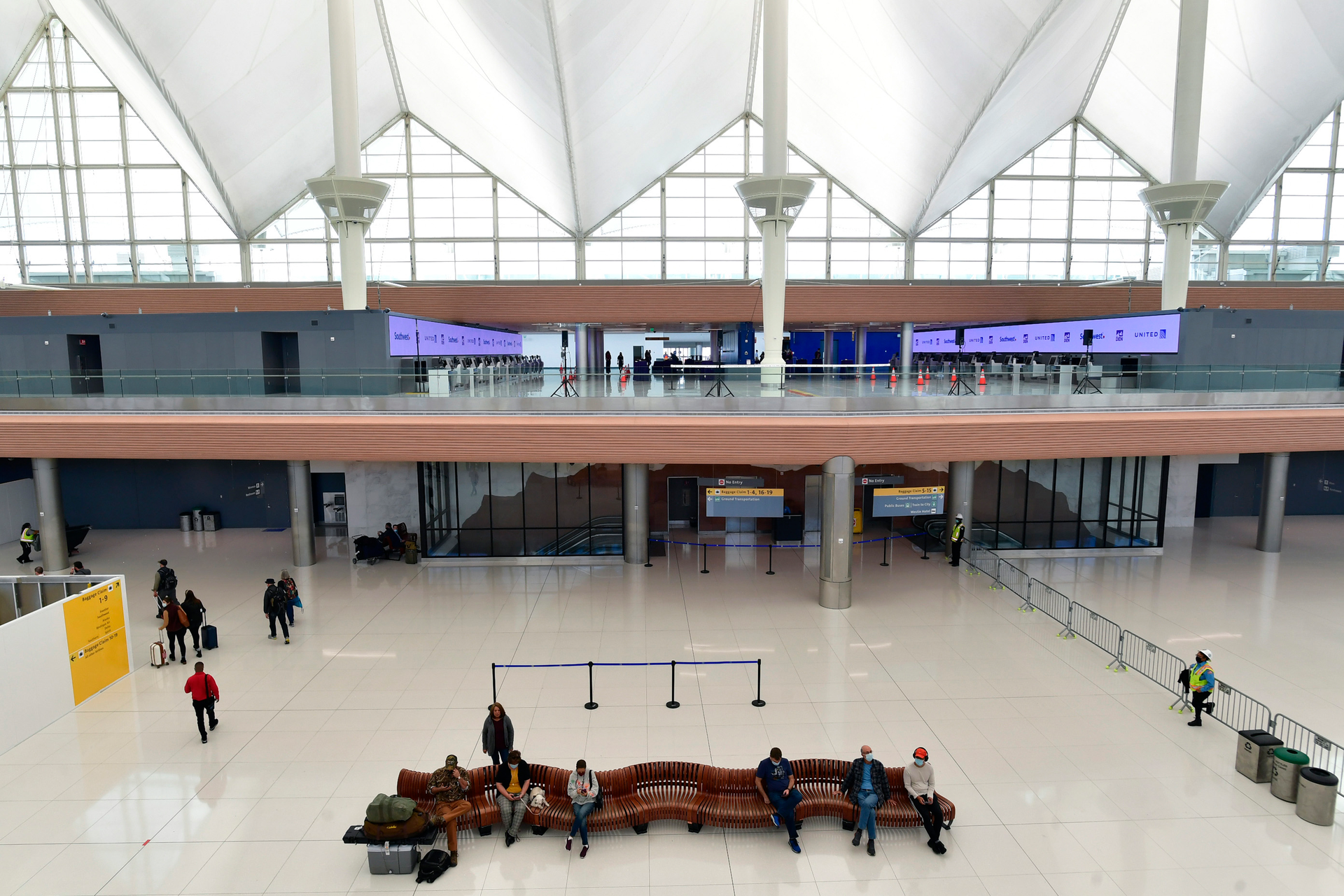 Travelers sit in part of the newly renovated areas on the 5th and 6th floor amid Phase 1 of terminal improvements on the $770 million Great Hall renovation project at Denver International Airport on Oct. 27, 2021, in Denver. The renovations created a more modern check-in experience and added capacity in the terminal as well as improving operational efficiency.