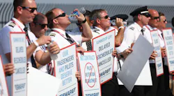 Southwest Airlines pilots drink water while picketing for better work conditions on June 21, 2022, outside Dallas Love Field.
