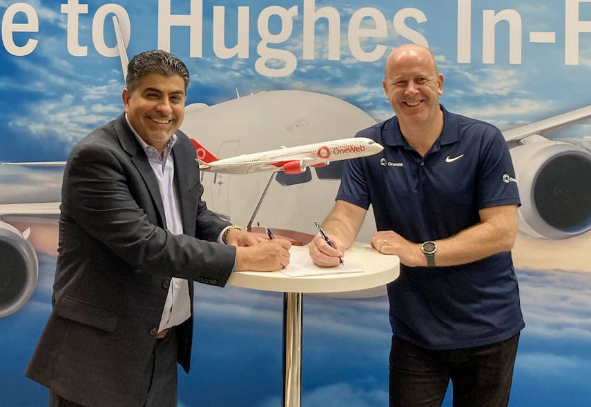 At the Hughes booth at the Airline Interiors Expo in Hamburg, Germany, Reza Rasoulian, vice president at Hughes, and Ben Griffin, vice president at OneWeb, sign the Distribution Partner agreement for Hughes to provide OneWeb Low Earth Orbit satellite connectivity services to global airlines and select partners.