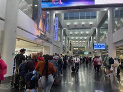 Dozens of passengers stand in line at a Miami International Airport terminal Sunday, July 16, 2023.