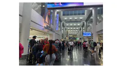 Dozens of passengers stand in line at a Miami International Airport terminal Sunday, July 16, 2023.