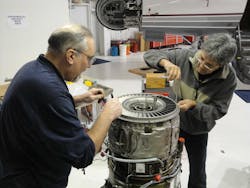 Joe Sabatini, at left, is shown performing a hot section inspection on a J85-5H engine in support of the experimental side of the house. Joe Sabatini, at left, is shown performing a hot section inspection on a J85-5H engine in support of the experimental side of the house.