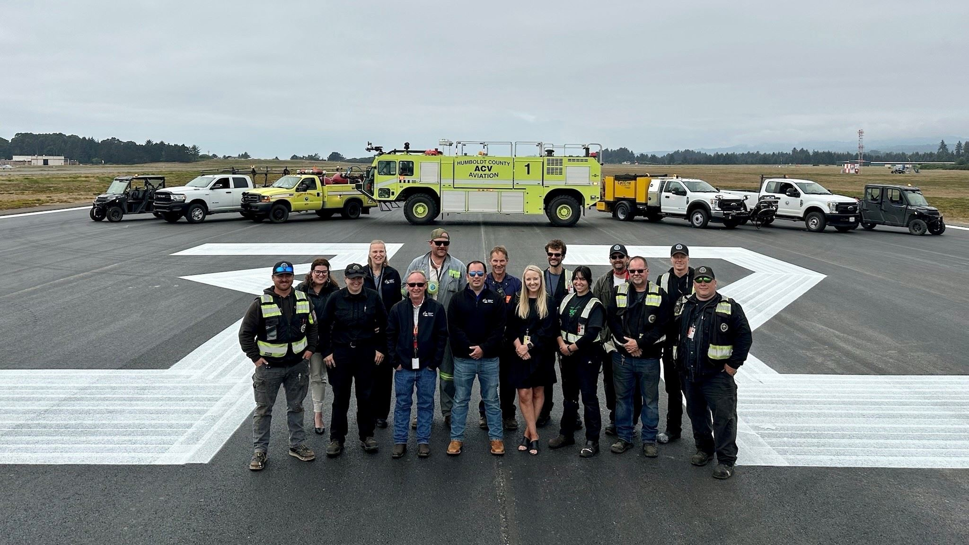In California, the County of Humboldt's Department of Aviation staff gather on the freshly repaved runway at the California Redwood Coast-Humboldt County Airport.