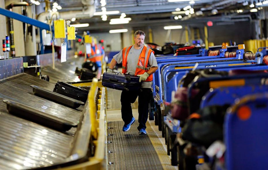 Southwest Airlines ramp agent Matt Lockby carries luggage in the baggage sorting area at Dallas Love Field Airport Thursday, October 2, 2014 in Dallas.