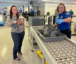 A traveler removes their pet dog from its travel carrier at the security checkpoint and sends the empty carrier into the X-ray machine as the TSA officer guides the passenger through the process. A traveler removes their pet dog from its travel carrier at the security checkpoint and sends the empty carrier into the X-ray machine as the TSA officer guides the passenger through the process.