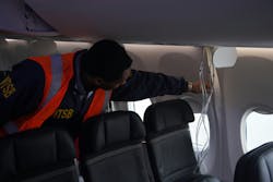 ​​NTSB investigator Dujuan Sevillian examining the interior side paneling of Alaska Airlines Flight 1282, a Boeing 737-9 MAX. ​​NTSB investigator Dujuan Sevillian examining the interior side paneling of Alaska Airlines Flight 1282, a Boeing 737-9 MAX.