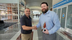 Jacob Gonzales (left), northeast regional manager at AES, congratulates Ryan Hall on winning the Team Leader of the Year.