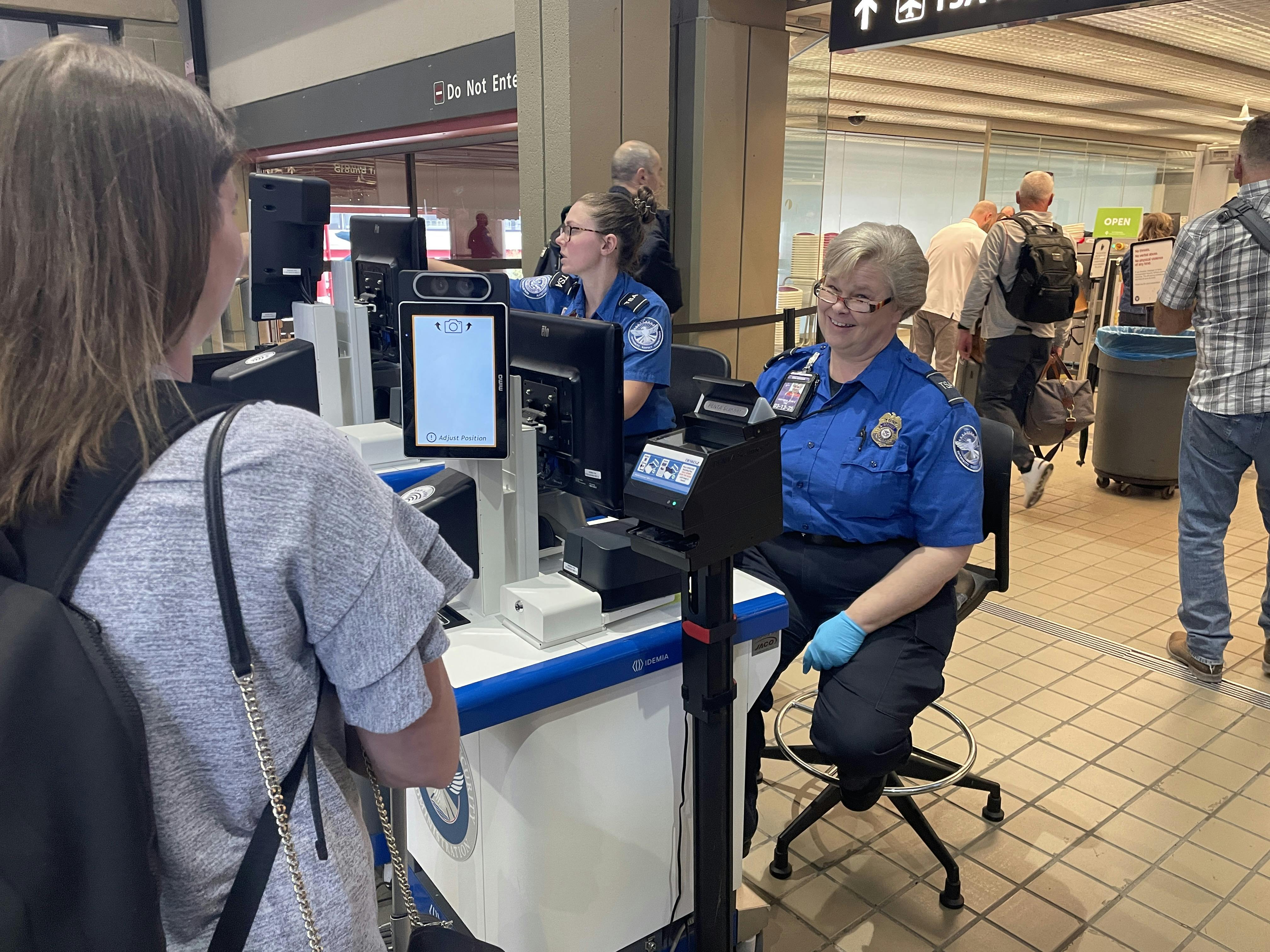 A traveler waits while the tablet captures her photo to immediately verify that her face matches the face on her ID.