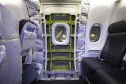 A panel has been removed that covered the door plug on a Boeing 737-9 Max parked near an Alaska Airlines hangar at SEA on Jan. 11, 2024. Four bolts and 12 stop fittings hold the door plug in place.