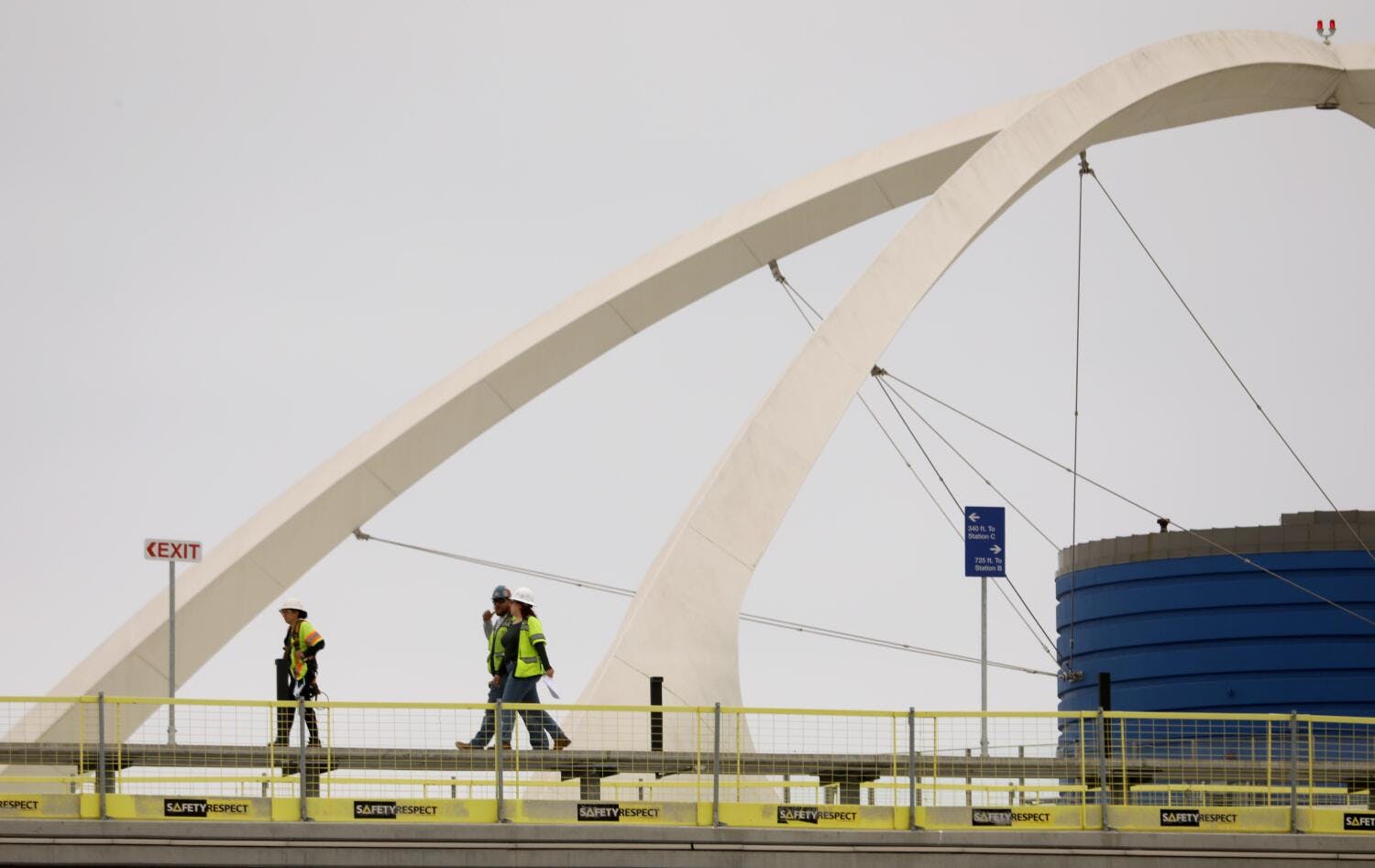 Workers, framed by the Theme Building, walk on the platform of what will be the the LAX Automated People Mover at Terminal 1 at the Los Angeles International Airport in Los Angeles on May 9, 2024.