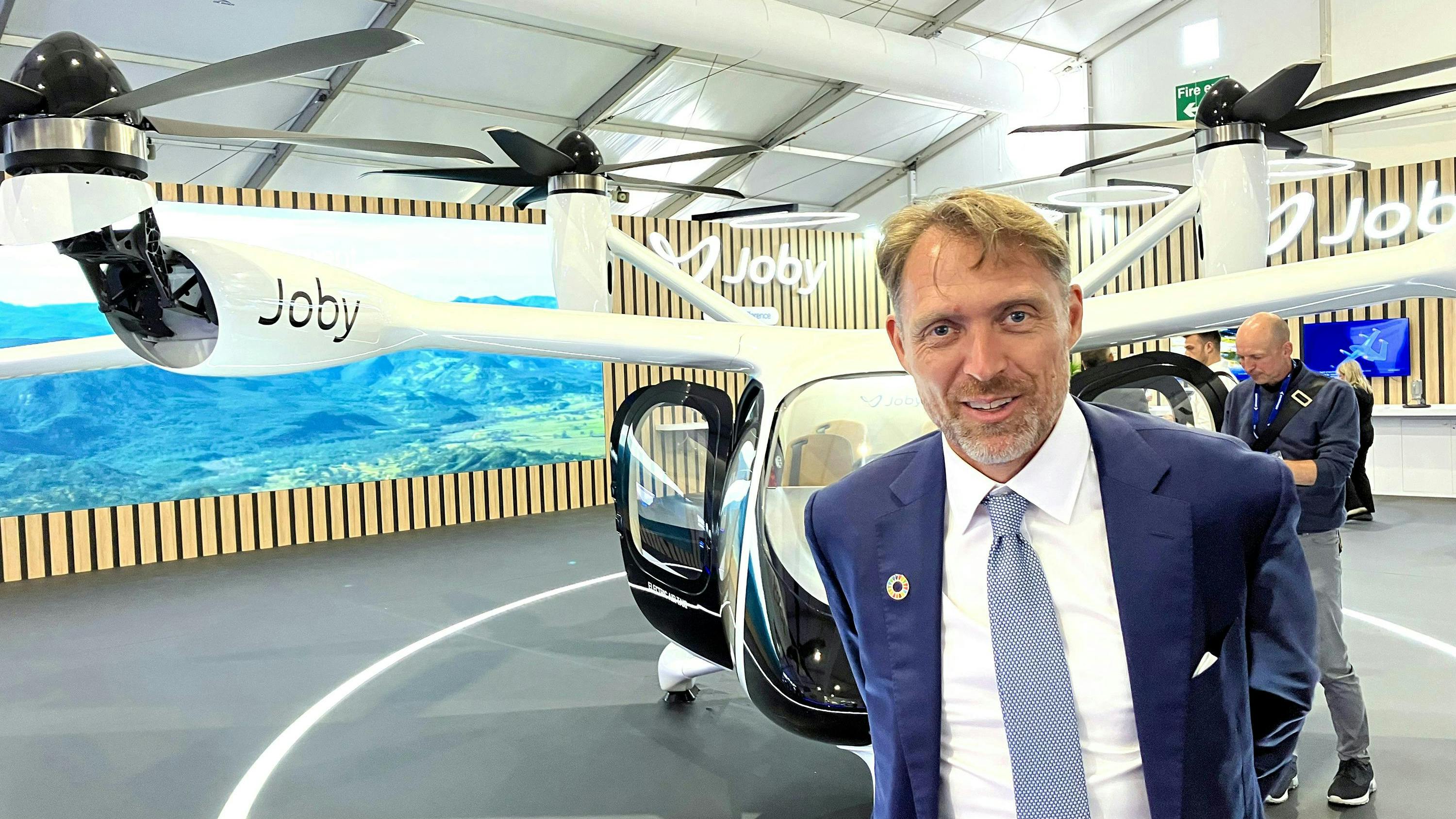 Joby Aviation founder and CEO JoeBen Bevirt with a mockup of the company&rsquo;s air taxi at the 2024 Farnborough Air Show.