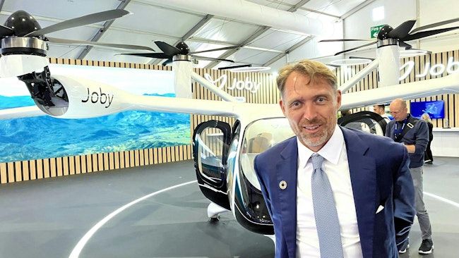 Joby Aviation founder and CEO JoeBen Bevirt with a mockup of the company’s air taxi at the 2024 Farnborough Air Show.