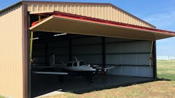 Mike Wagner’s Mooney M20J fits nicely in his new 42-foot by 84-foot hangar equipped with a 40-foot by 14-foot Schweiss Doors bifold liftstrap door. When opened the bifold door provides a shaded canopy for the hangar.
