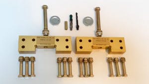 A collection of brass-colored landing gear parts, including screws and drill bits, against a white background