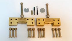 A collection of brass-colored landing gear parts, including screws and drill bits, against a white background A collection of brass-colored landing gear parts, including screws and drill bits, against a white background