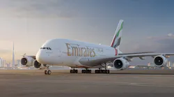 An airplane with the text 'Emirates' on it sits on a tarmac with the sun behind
