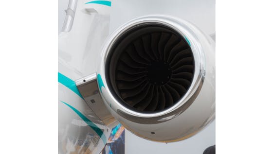 a close-up shot of an airplane engine attached to a white and light blue airplane