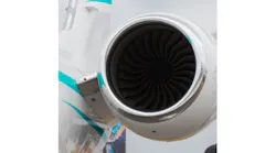 a close-up shot of an airplane engine attached to a white and light blue airplane