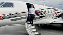 A man in business attire stepping out of a jet plane onto a staircase A man in business attire stepping out of a jet plane onto a staircase