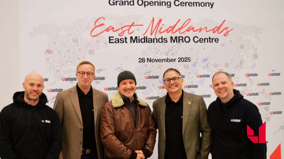 Five people stand smiling in front of a sign that reads, 'East MIdlands MRO Centre'