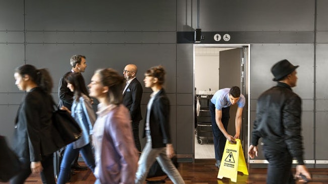 An airport custodial team member prepares a restroom during peak passenger flow, underscoring how real-time hygiene operations support smoother holiday travel and improved non-aeronautical revenue opportunities.