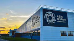 A large white building with a sign that reads 'Aero Norway Quality Engines' sits in front of a setting sun