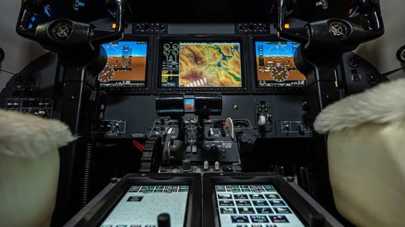 A flight deck with black hardware and an array of buttons and screens